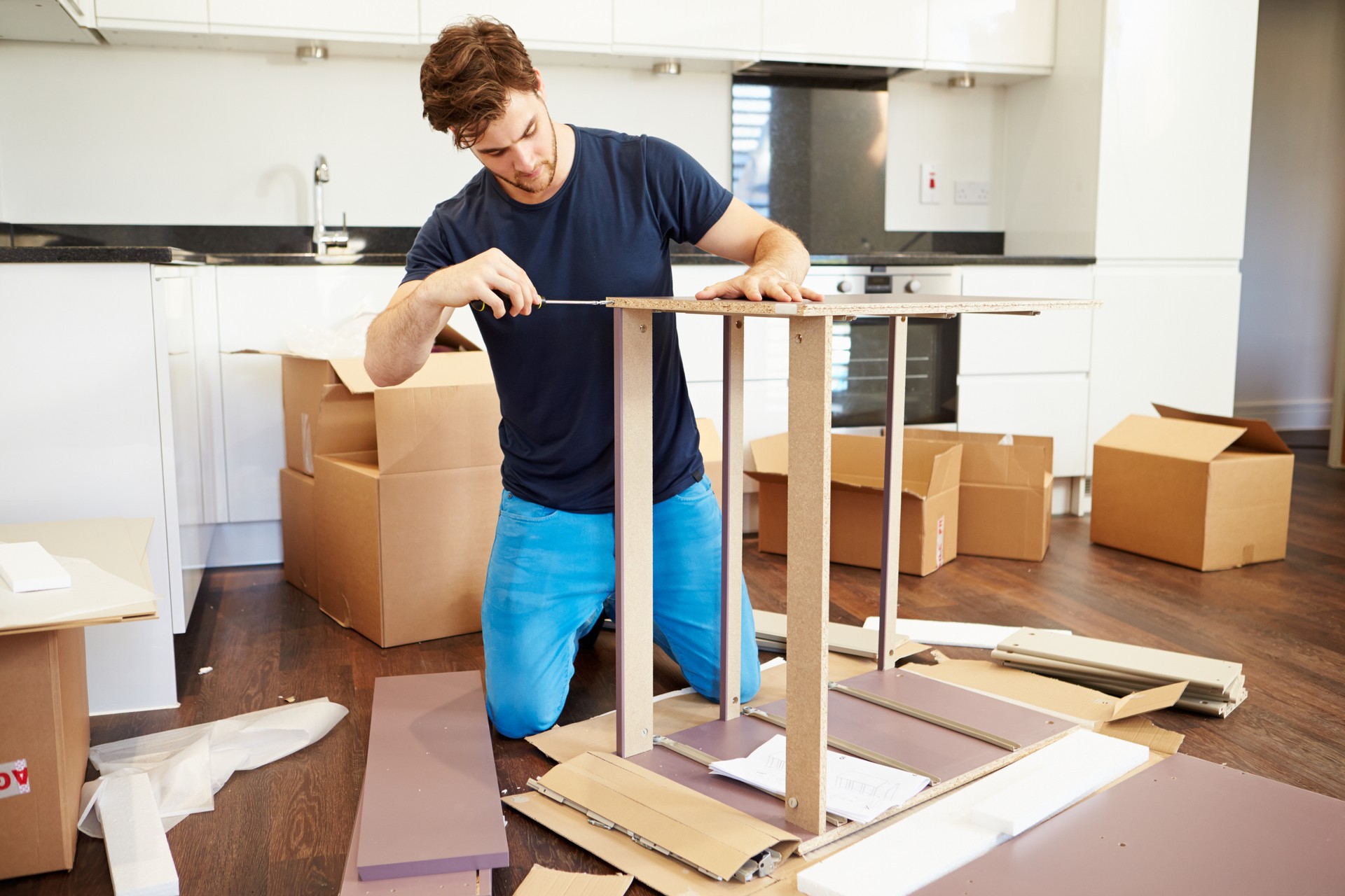 Man assembling furniture in his new home