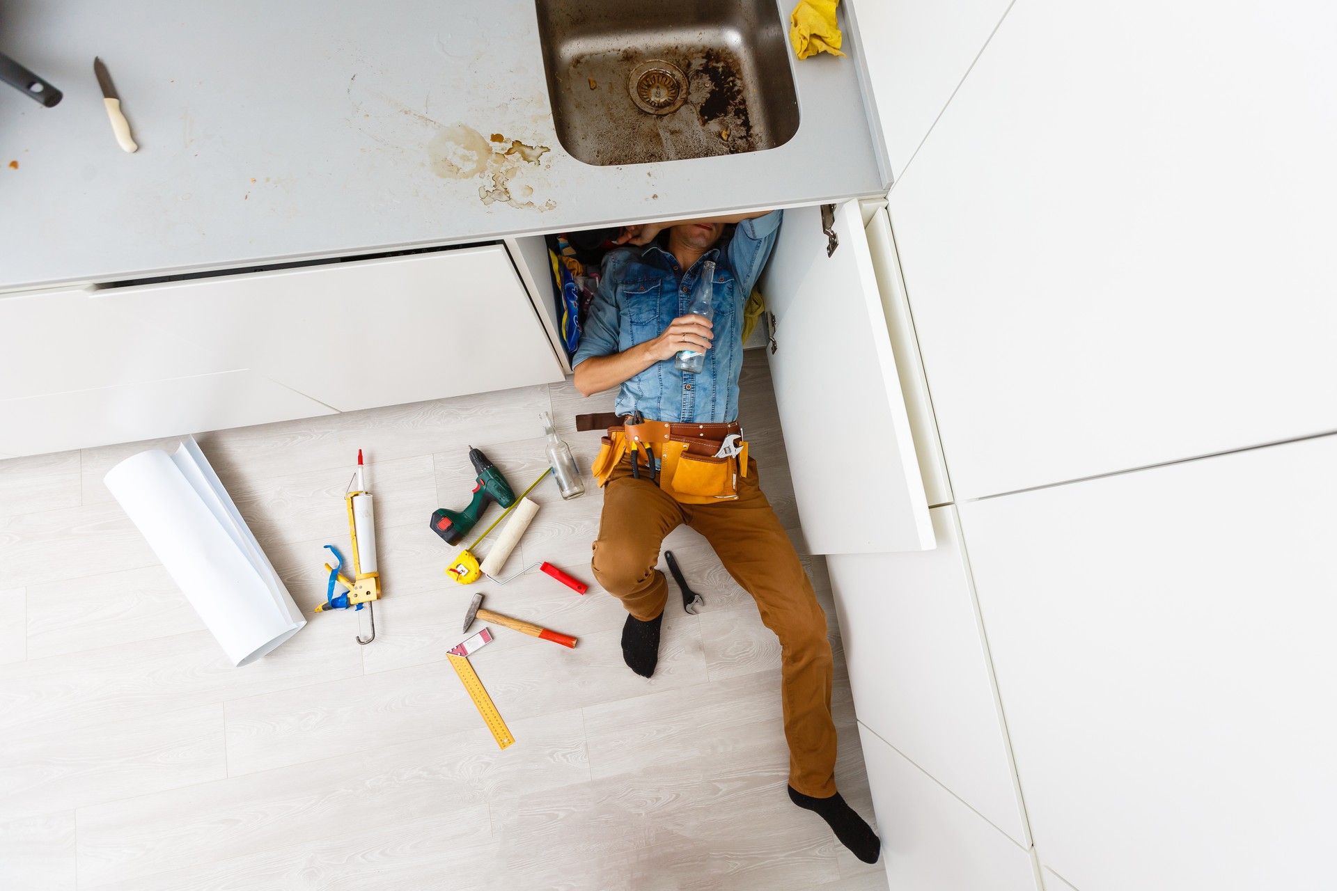 Handsome professional plumber doing sink reparation. Contractor.